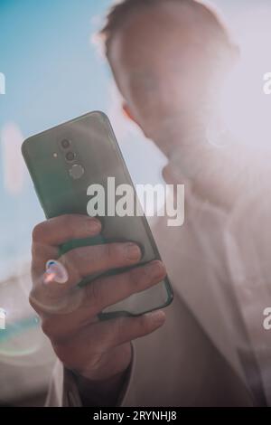 A businessman using his smartphone outdoors, showcasing the seamless integration of technology and mobility in modern profession Stock Photo
