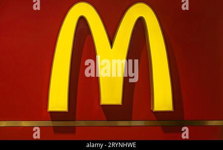 McDonald's restaurant sign. The McDonald's Corporation is the world's largest chain of hamburger fast food restaurants. McDonald's logo on red backgro Stock Photo