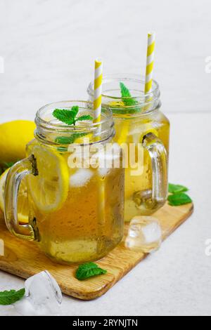 Green ice tea with lemon and mint in a glass jar. Stock Photo