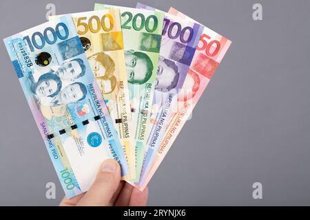 Philippine money in the hand on a gray background Stock Photo