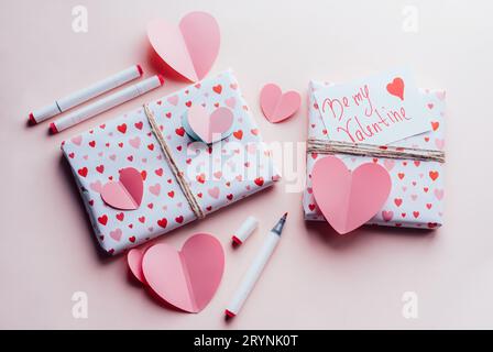 Pink conceptual background for Valentine's Day. Wrapped gift boxes decorated with hearts. Stock Photo