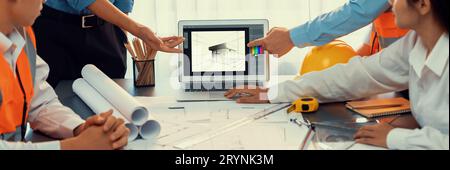 Engineer and architect working together brainstorming and designing blueprint using laptop working with architectural software for precise digital Stock Photo