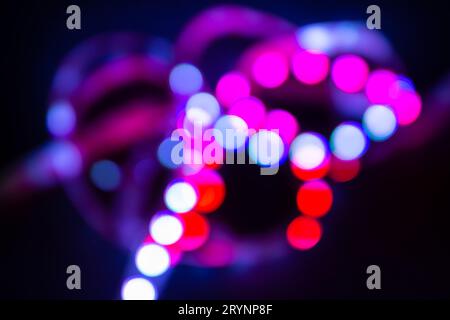Purple Neon bokeh lights on black. Abstract blurred background Stock Photo