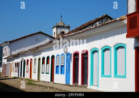 Typical house facades in sunshine with colorful doors and windows, in the background church steeple Stock Photo