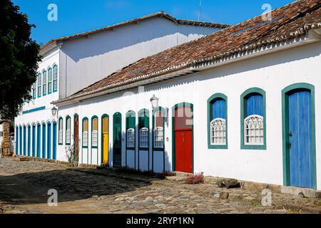 Typical house facades with colorful doors and windows on sunny day in historic town Paraty, Brazil, Stock Photo