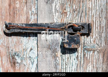Old rusty hinge on a weathered wooden door. Shallow depth of field Stock Photo