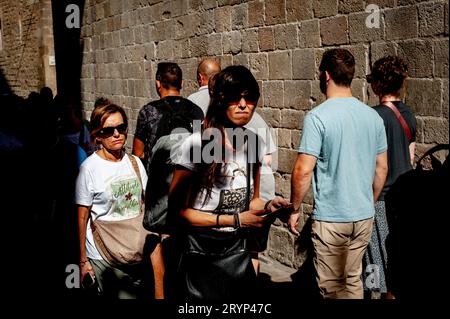 Visitors walk along Barcelona's downtown streets in the Gothic Quarter. Stock Photo