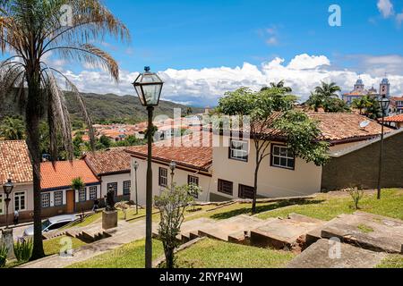 View to a green area with sloping steps and traditional buildings  in background, blue sky with whit Stock Photo
