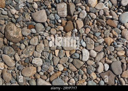 River pebbles with different textures close-up. Stone background. Stock Photo