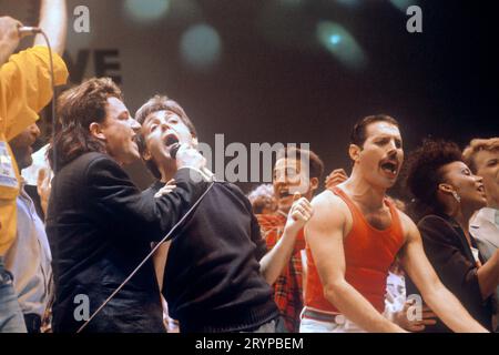File photo dated 13/07/85 of (left to right) Bono, Paul McCartney, Andrew Ridgeley and Freddie Mercury during the Live Aid concert at Wembley Stadium. A musical adaption of the 1985 concert is set to premiere on the West End stage. The musical, titled Just For One Day, will include songs from stars Sir Paul McCartney, Sir Elton John, David Bowie and Queen that featured during the original performance. The stage adaption, written by British author John O'Farrell, will premiere at The Old Vic theatre on January 26 until March 30 2024. Issue date: Monday October 2, 2023. Stock Photo