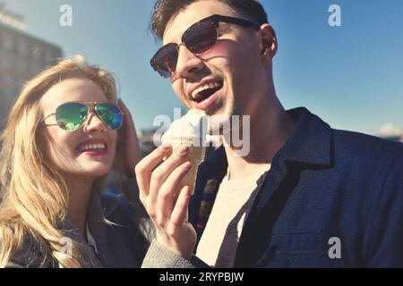 Beautiful couple stay at city embankment and eating the ice cream Stock Photo
