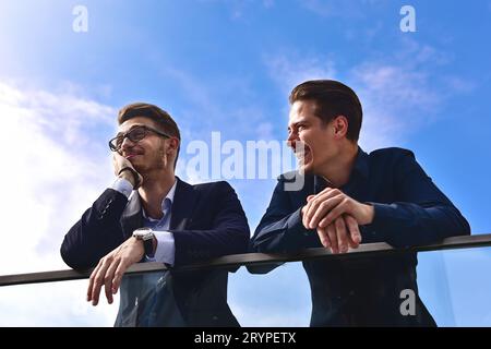 Two smiling colleagues speaking and having fun at street. Stock Photo