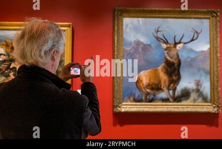 Man taking photo of Monarch of the Glen stag painting by Sir Edwin Landseer, National Galleries of Scotland newly opened extension, Edinburgh, UK Stock Photo