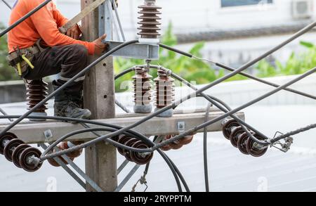 High voltage power line maintenance. Electrician at work. Electrical technician working on electric pole. High voltage power line construction. Danger Stock Photo