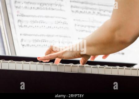 Female hands of a pianist musician and piano keys close up Stock Photo