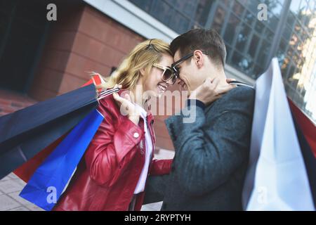 Beautiful young loving couple carrying shopping bags and enjoying together. Picture showing young couple shopping in the city. Stock Photo