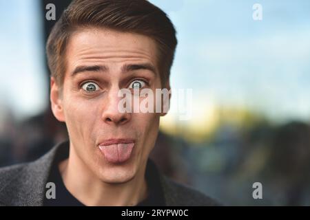 Portrait of stylish happy handsome young man standing outdoors. Stock Photo