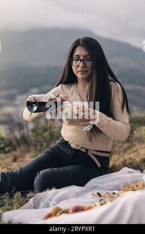 Woman with a wine bottle and cup in the hands over nature background Stock Photo