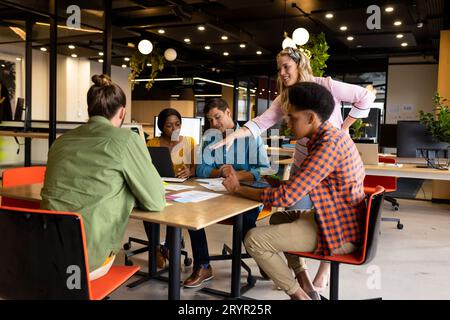 Diverse creative colleagues in discussion brainstorming using notes, tablet and laptop Stock Photo
