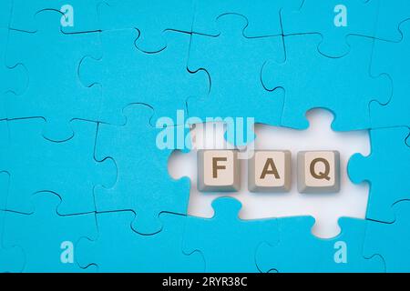 FAQ message on the computer keyboard keys placed among blue puzzle Stock Photo