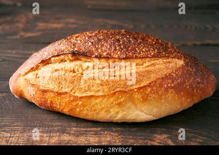 Loaf of fresh made white bread on wooden table background. Stock Photo