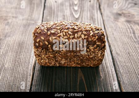 Loaf of fresh made rye multigrain bread on wooden table background Stock Photo