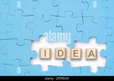 IDEA message on the computer keyboard keys placed among blue puzzle Stock Photo