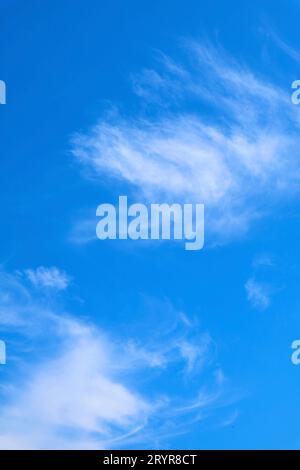 Feathery White Clouds Flowing on Vibrant Blue Sky Stock Photo
