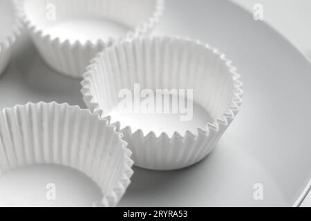 Cupcake and muffins corrugated paper molds. Empty stacked kitchen tools for sweet pastries on white background Stock Photo