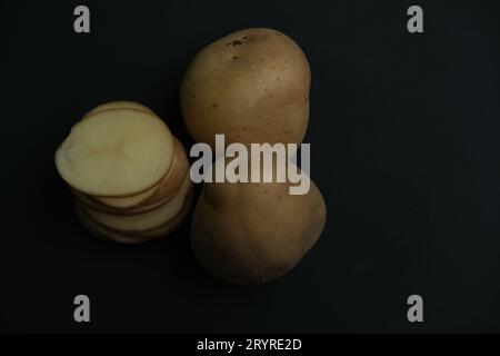 stacked and whote  potato slices on black background. top view Stock Photo