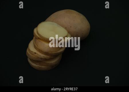 stacked  potato slices on black background. close up view Stock Photo