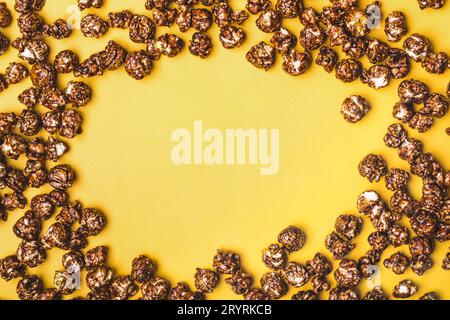 Frame of chocolate popcorn on a yellow background Stock Photo