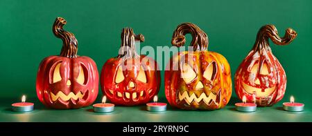 Halloween diy ceramic pumpkins jack lantern and candles on pine green banner Stock Photo