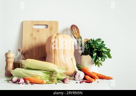 Autumn seasonal vegetables and kitchen utensils still life on table wall background. Thanksgiving food concept Stock Photo