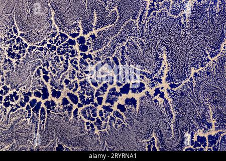 Acrylic Fluid Art. Gold sparkles wavy pattern on dark blue background. Abstract background or texture Stock Photo