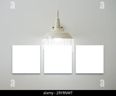 Mockup three square white blank picture frames set hanging under the vintage glowing light lamp on white background, minimal style. Template space for Stock Photo