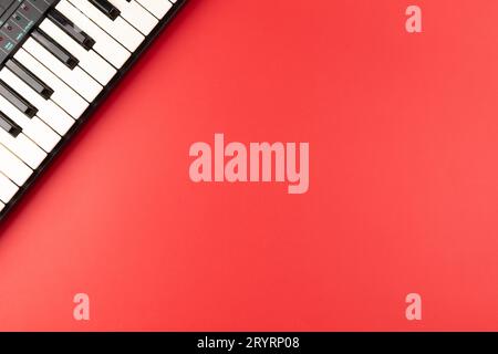 Vintage electronic keyboard synth piano on red background Stock Photo