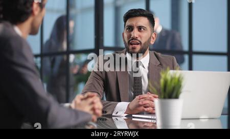 Two medium focused business workers communicate in the office. Stock Photo