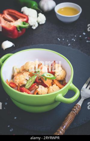 Vegetable stew of cauliflower, carrots and Bell peppers on a black background Stock Photo
