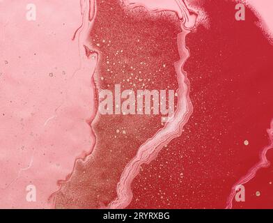 Acrylic Fluid Art. Golden splashes on pink and red waves. Abstract creative background or texture Stock Photo