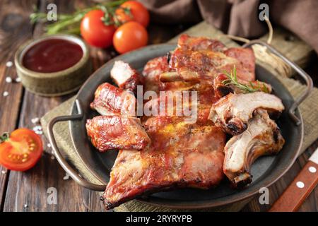 BBQ grilled veal calf brisket meat on short spare rib on plate over rustic wooden table. Stock Photo