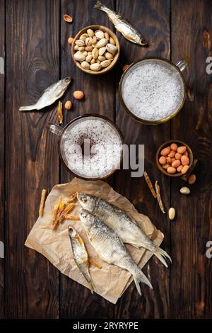 Alcohol drink pint of lager and pint of stout, craft beer. Two Glass of Beer with foam and snacks on a wooden rustic background. Stock Photo
