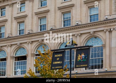 Hanging signs outside the Duchess Of Cornwall inn pub, Hall & Woodhouse pub,  in Queen Mother Square at Poundbury, Dorchester, Dorset UK in September Stock Photo