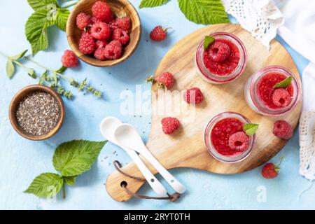 Healthy breakfast. Chia seed pudding with raspberry and jam or smoothies with chia seeds on a stone table. View from above. Stock Photo