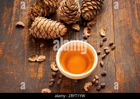Cedar oil, nuts and cones On a wooden background. Top view Stock Photo