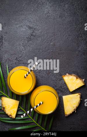 Pineapple juice or smoothies and pineapple slices on a black background Stock Photo