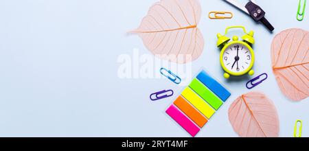 School supplies and orange leaves on a blue background Stock Photo