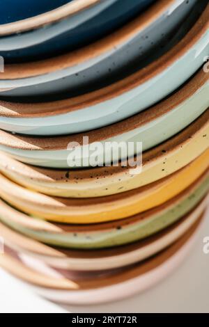 A large stack of ceramic cups in pastel colors. Stock Photo