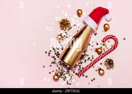 Christmas composition made of Golden champagne in Santa hat, candy cane and sparkles, copy space Stock Photo