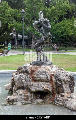 small fontain with statue on a rock in Ruse garden, Bulgaria Stock Photo